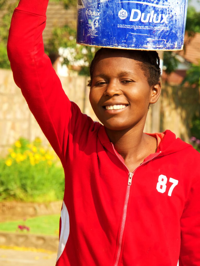 Una chica llevando agua de un pozo en Harare (Zimbabue)